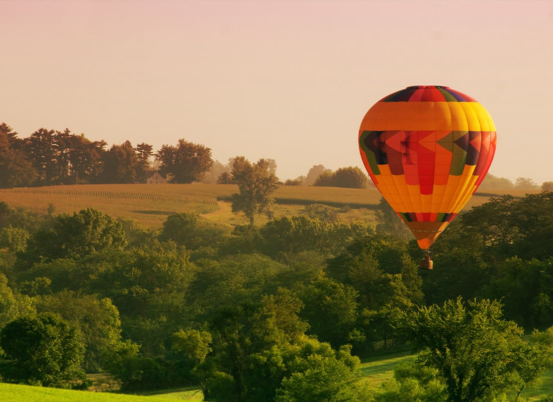 Harlan, IA - Hot Air Balloon Above Lush Tress in the Countryside